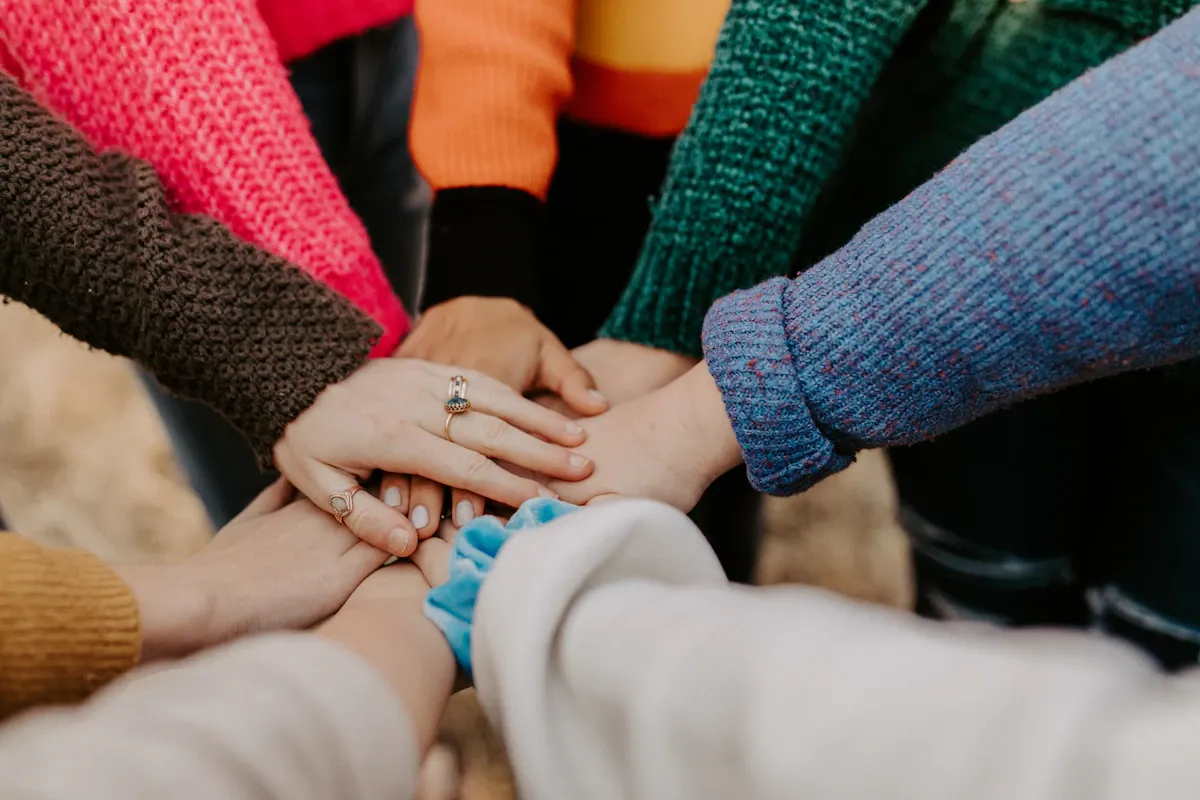 A group of people bringing their hands together in solidarity